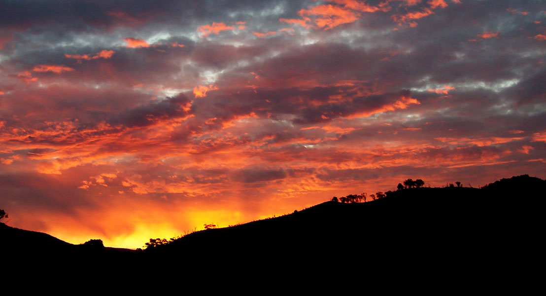 Stratified sunset color bands — orange, pink, violet and deep blue horizons.